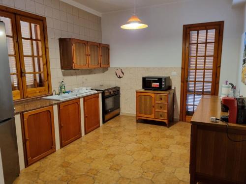 a kitchen with wooden cabinets and a stove top oven at Villa Pina Arenella in Arenella