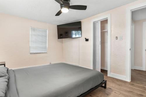 um quarto com uma cama e uma ventoinha de tecto em Westshore Stadium House em Tampa