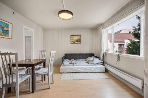 ein Wohnzimmer mit einem Bett, einem Tisch und einem Fenster in der Unterkunft Dinbnb Homes I 4-Bedroom Historical House in Romantic Surroundings in Bergen