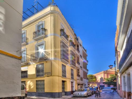 un edificio amarillo con coches estacionados frente a él en Reservaloen Casa del Museo en Sevilla