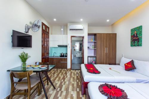 a room with a bed and a table and a kitchen at Le House Hotel and Studio in Danang