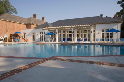a large swimming pool with blue chairs and a building at Williamsburg Lodge, Autograph Collection in Williamsburg