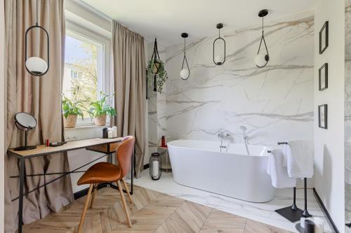 a bathroom with a white tub and a desk at Secret Garden Apartment in Warsaw