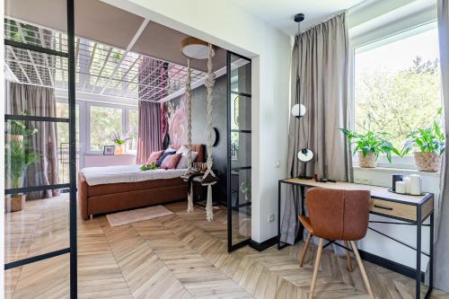 Secret Garden Apartment في وارسو: غرفة نوم مع سرير ومكتب