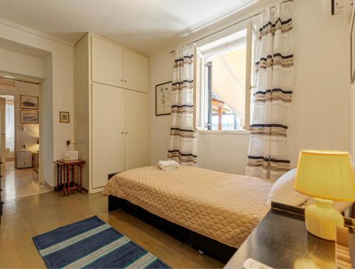 a bedroom with a bed and a large window at Eutuxia House in Corfu Town