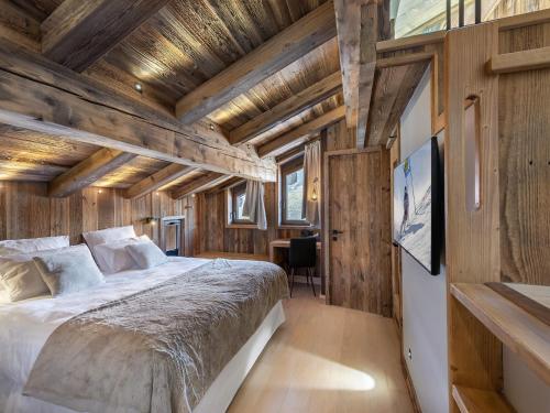 - une chambre avec un grand lit dans une cabane en bois dans l'établissement Chalet à Courchevel Le Praz : Piscine, Ski Room, Billard, 6 Adultes + 2 Enfants, Proche Pistes - FR-1-568-14, à Courchevel