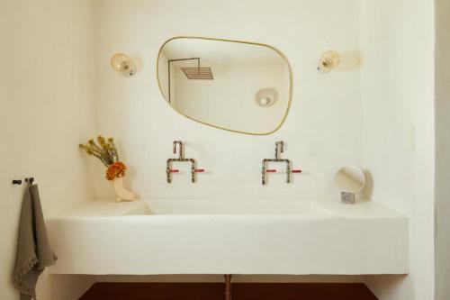 a bathroom with a white sink and a mirror at DUNA by DW in San Juan