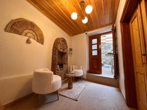 - un salon avec une chaise et une cheminée dans l'établissement Hanole Guest House, à Ayvalık