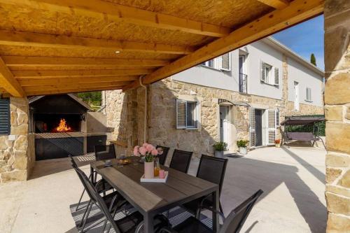 une terrasse avec une table et une cheminée dans l'établissement Holiday Home Toni, à Kaštel Stari