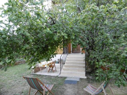 un escalier avec des chaises et une table sous un arbre dans l'établissement Appartement pour 3 personnes à Sarlat, à Sarlat-la-Canéda