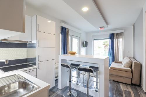 a kitchen with a sink and a counter with stools at Boutique Apartments Blitz in Bibinje