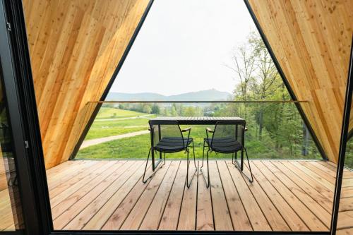Habitación con mesa y 2 sillas en una terraza de madera. en Baumhausapartment, en Breuberg