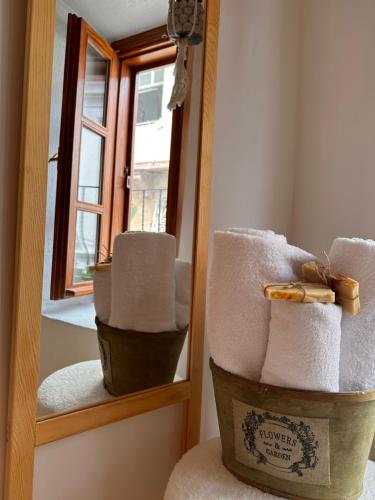 a stack of towels in front of a mirror at Hanole Guest House in Ayvalık