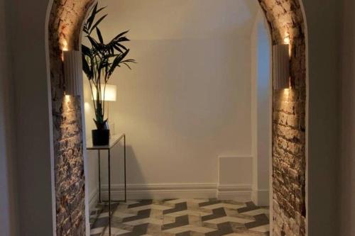 a hallway with an archway with a potted plant at Luxurious 2 bedroom apartment with sea view in Monkstown in Blackrock