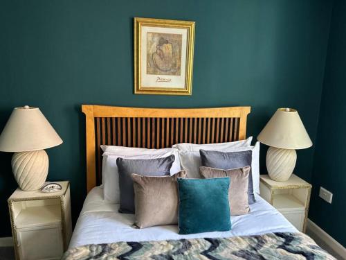 a blue bedroom with a bed with pillows and two lamps at John Street Apartment 3 in Bristol