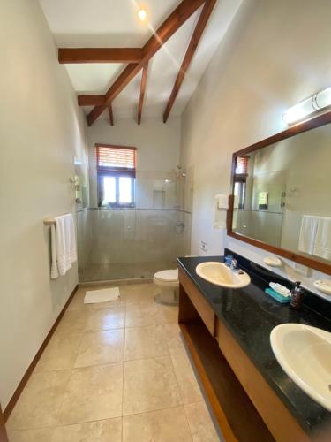 a bathroom with two sinks and a toilet and a mirror at Club del Cielo Condominium Rental in Jacó