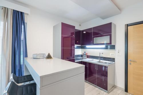 a kitchen with purple cabinets and a sink at Boutique Apartments Blitz in Bibinje