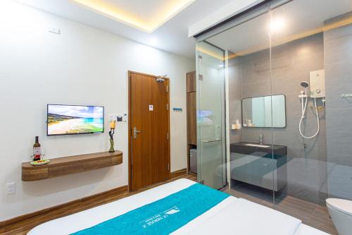 uma casa de banho com uma cama e uma cabina de duche em vidro em Le House Hotel and Studio em Da Nang
