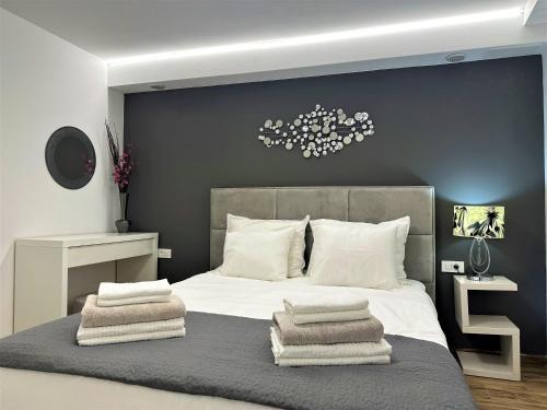 a bedroom with a large bed with towels on it at HILLSIDE Apartment Volosko in Opatija