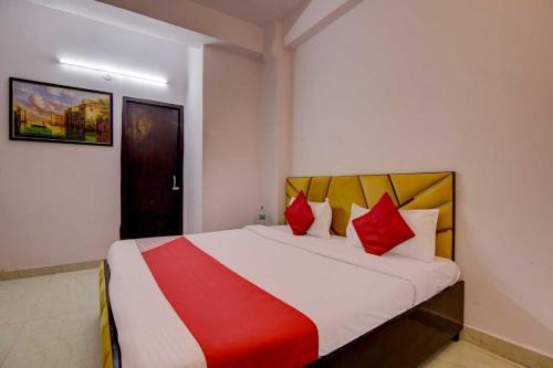 a bedroom with a large bed with red pillows at OYO Flagship Decent Residency in New Delhi