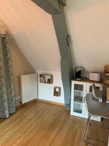 un salon avec une table et une cuisine dans l'établissement Charmant appartement rénové, à Bayeux