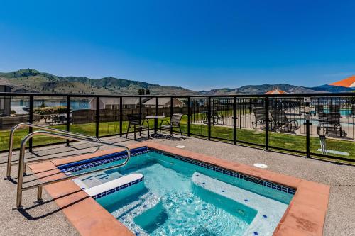 a hot tub on a balcony with a view of the mountains at Lake Chelan Shores Happy Days 19 2 in Chelan