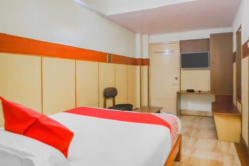 ein Hotelzimmer mit einem Bett mit einem roten Kissen in der Unterkunft Flagship Sai Vishram in Bangalore