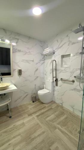 a white bathroom with a toilet and a sink at El Solar de Nené in Ajo