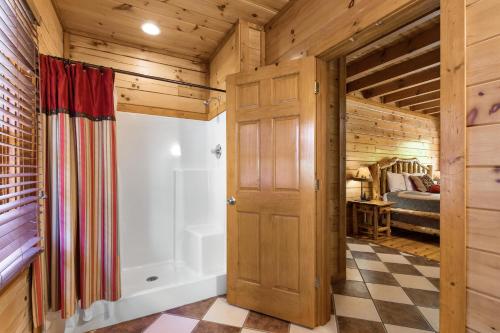 uma casa de banho com um chuveiro e uma banheira em Mountain Cinema Lodge em Pigeon Forge