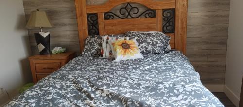 ein Schlafzimmer mit einem Bett mit einem Blumenkissen darauf in der Unterkunft WineDownHere - Lic. 75806 in Kelowna