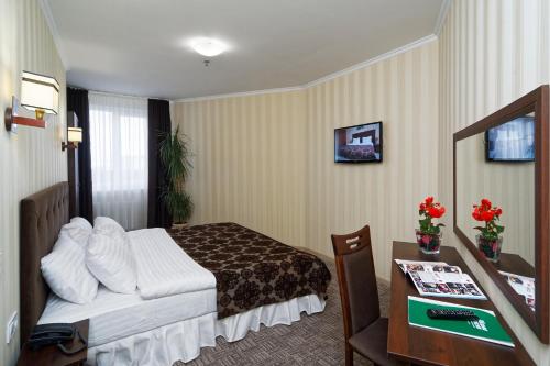 a hotel room with a bed and a desk at Lisova Pisnia Resort Hotel in Truskavets