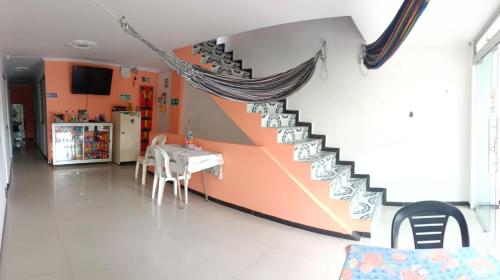 a staircase in a room with a table and a kitchen at Hotel El Paisano in Villavicencio