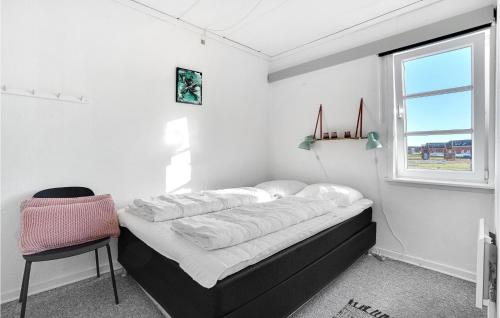een bed in een kamer met een stoel en een raam bij 2 Bedroom Amazing Apartment In Rm in Sønderby