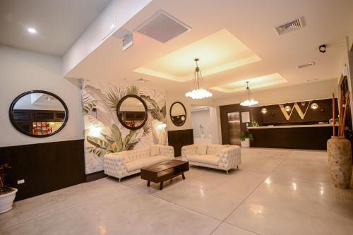 a lobby with two chairs and a table and mirrors at The Watermark Hotel in San Pedro