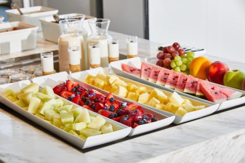 a buffet with three trays of fruit on a table at AC Hotel by Marriott Santiago Cenco Costanera in Santiago