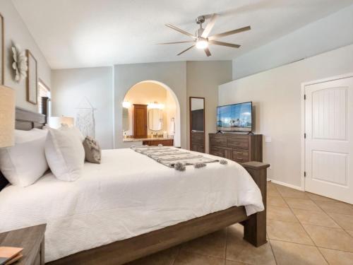a bedroom with a large bed with a ceiling fan at Chandler Earhart in Chandler