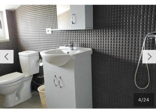 a bathroom with a white sink and a toilet at Home guest in Tirana