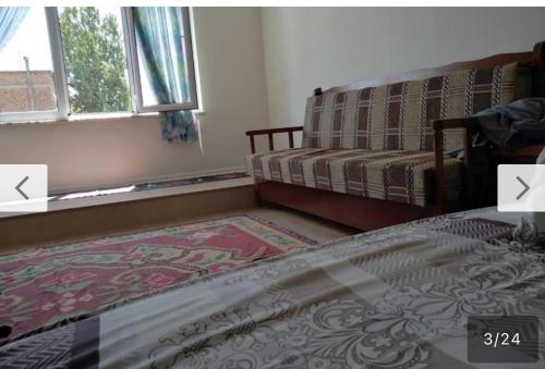 a bedroom with a bed and a couch and a window at Home guest in Tirana