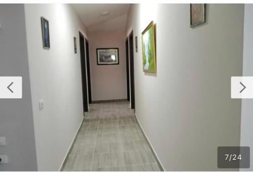 a hallway with white walls and pictures on the walls at Home guest in Tirana