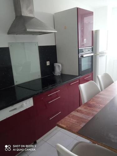 a kitchen with red cabinets and a counter top at Le lumineux sobre in Melun