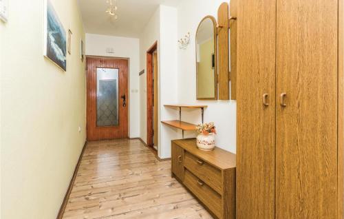 a hallway with a wooden dresser and a door at Stunning Apartment In Marcana With 3 Bedrooms And Wifi in Loborika