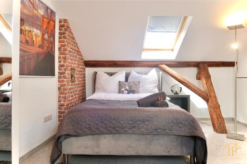 1 dormitorio con cama y pared de ladrillo en Gemütliche, zentrale & schöne Loft Wohnung, en Bamberg