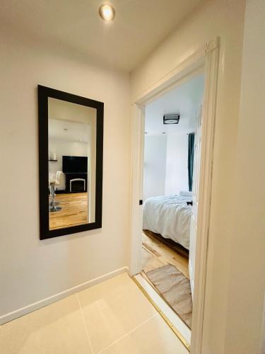 a bedroom with a mirror and a bed in it at SAI GON Suit in Grimsby