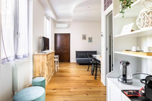 Il comprend une cuisine et un salon avec une table et des chaises. dans l'établissement La Corte Albenga, à Albenga