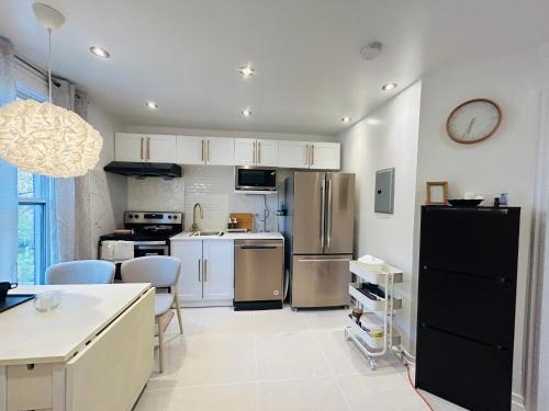 a kitchen with stainless steel appliances and white cabinets at SAI GON Suit in Grimsby