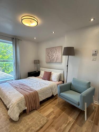 a bedroom with a bed and a blue chair at SAI GON Suit in Grimsby