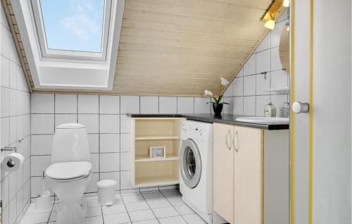bagno con servizi igienici, lavandino e lavatrice. di Lejlighed 119 a Rømø Kirkeby