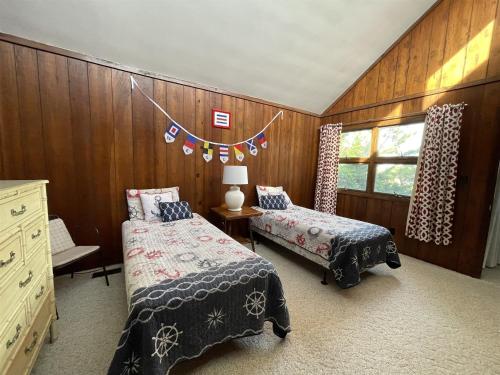a bedroom with two beds and a window with flags at Elizabeth House 56126 in Hatteras