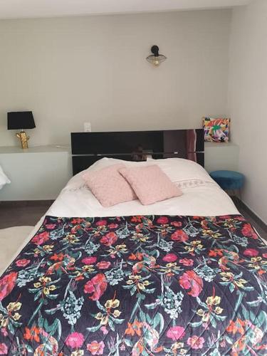 - une chambre avec un lit doté d'une couette à fleurs dans l'établissement Gîtes avec piscine chauffée, à Rosnay