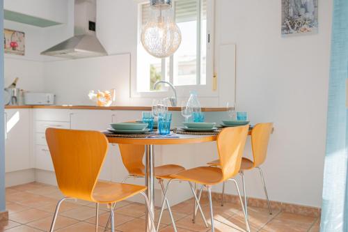 a kitchen with a table and four chairs at Apartamentos Turisticos CAN CUNILL in Es Pujols
